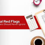 Desk with calculator, coffee, clock, financial red flags and financial records