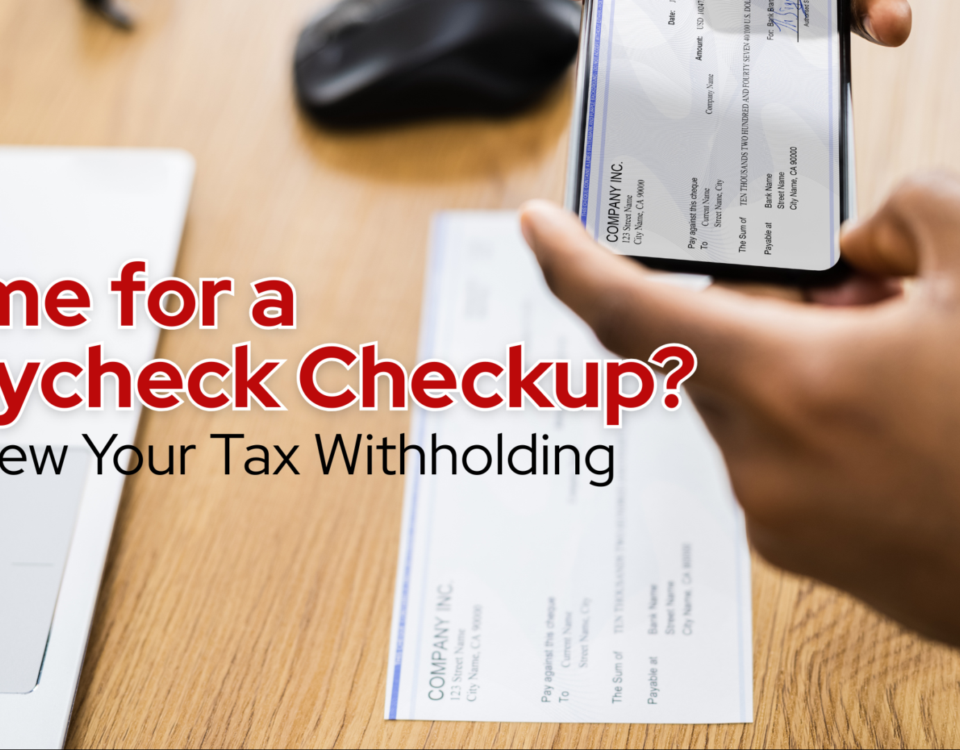 tax withholding and payrolll details being reviewed with a paycheck and mobile banking app